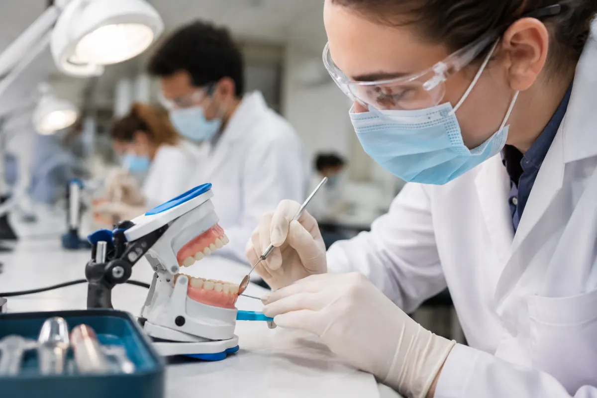 Mannequin dentaire et instruments de simulation sur le bureau d'un étudiant en dentisterie