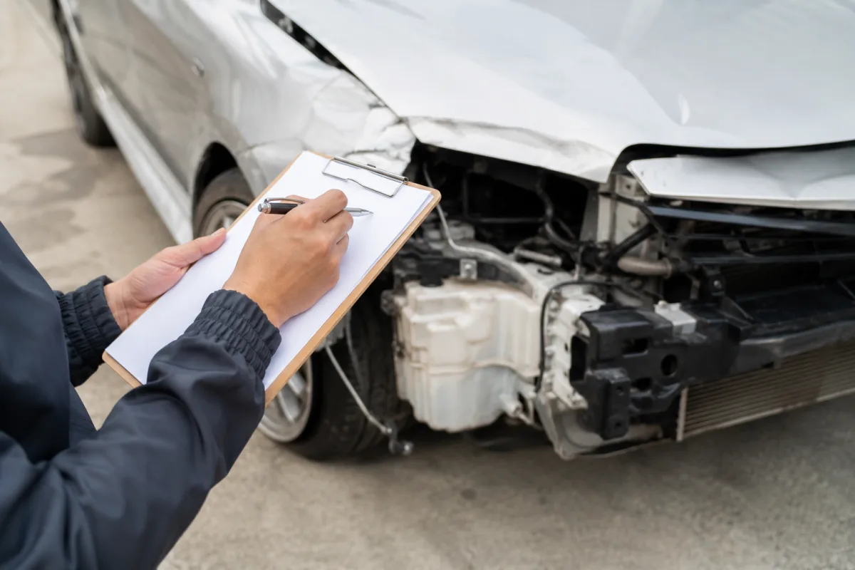 Gros plan sur le rapport rédigé par un expert automobile posé sur le capot